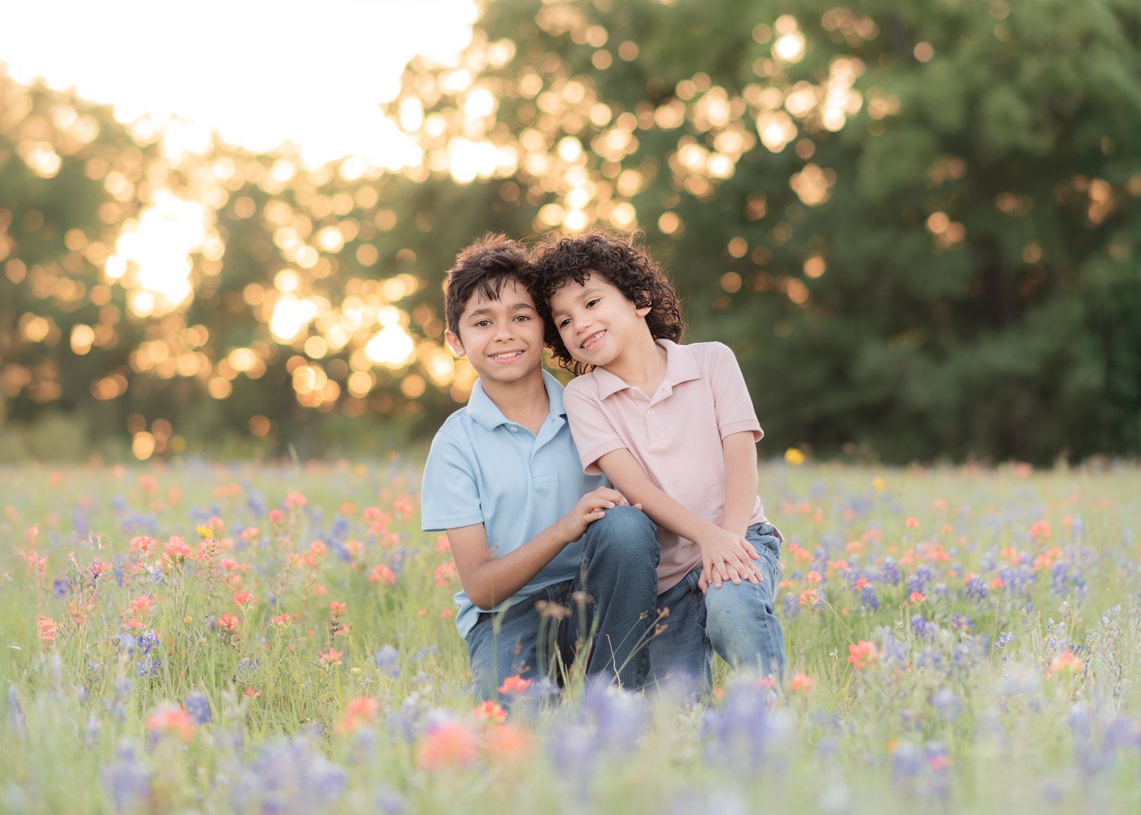 Teresa Vitela bluebonnet session - two young kids in blue and pink outfits smiling together in bluebonnet field Bryan Texas