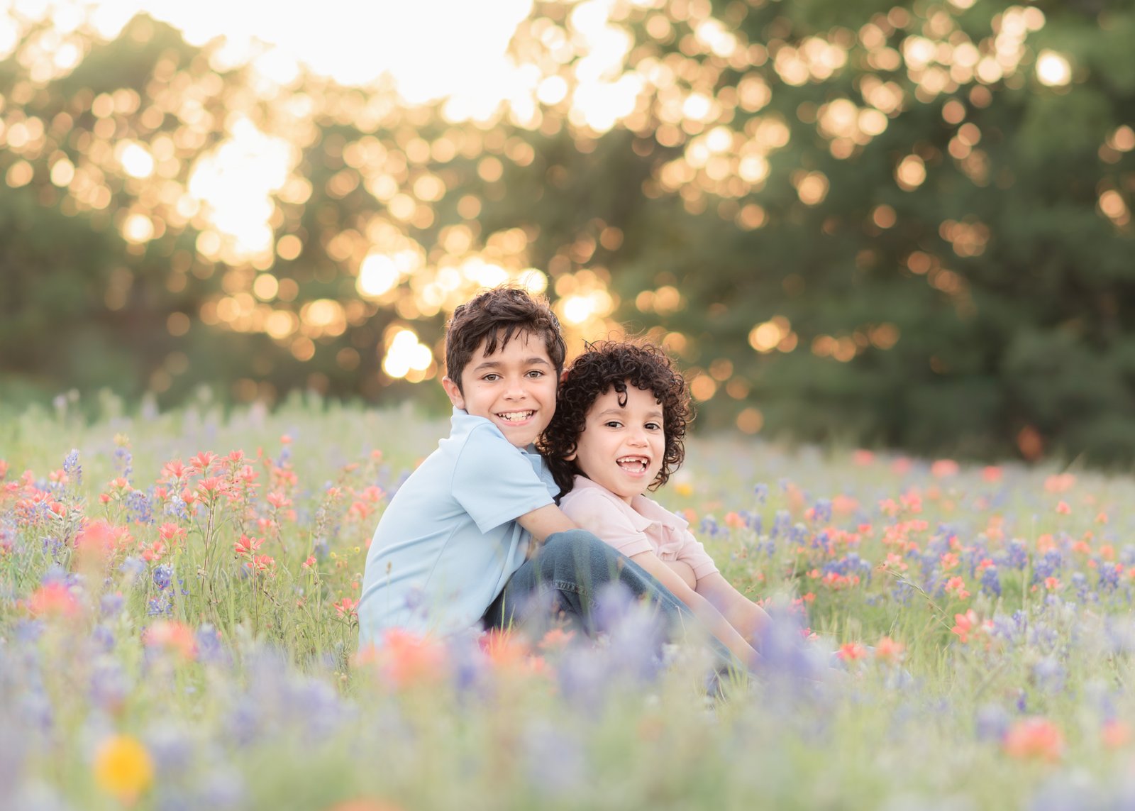 Teresa Vitela spring portrait - happy young siblings in coordinated outfits laughing in Texas bluebonnets College Station Texas