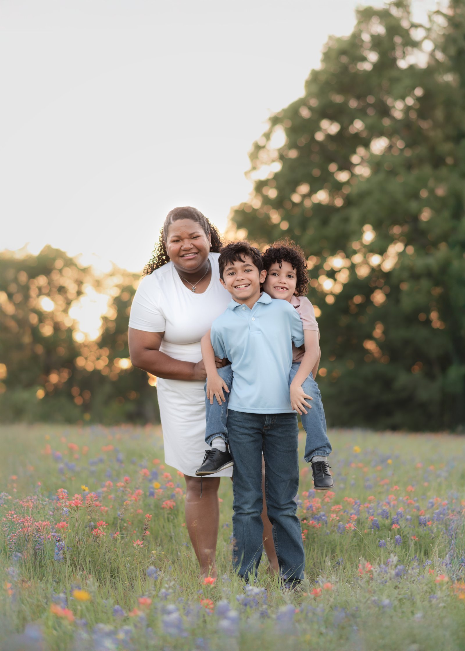 Teresa Vitela bluebonnet family photography - mom in white dress, dad in teal polo young kids laughing in bluebonnet field Bryan Texas