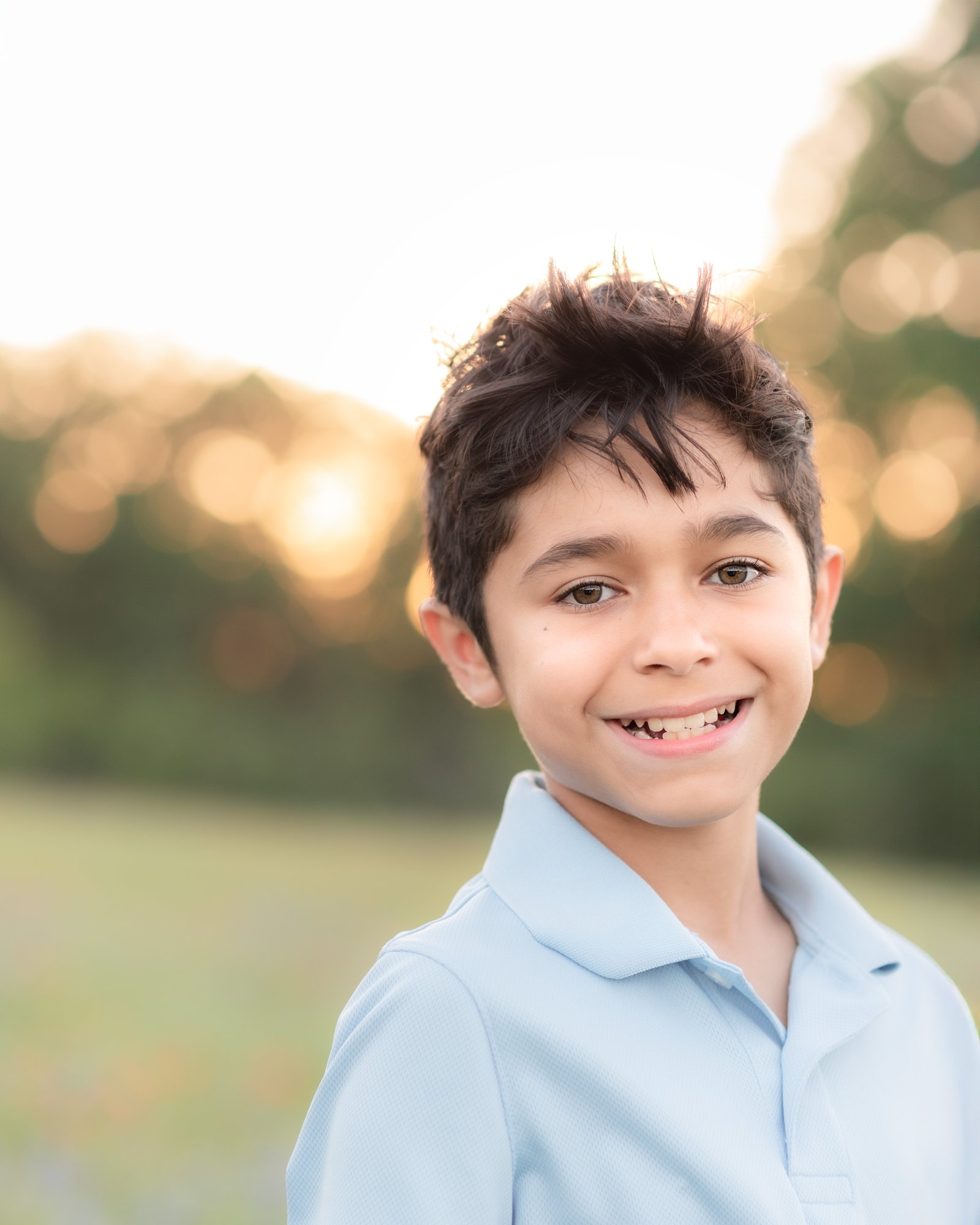 Teresa Vitela bluebonnet portrait - young boy in blue shirt smiling in Texas bluebonnet field Bryan College Station Texas