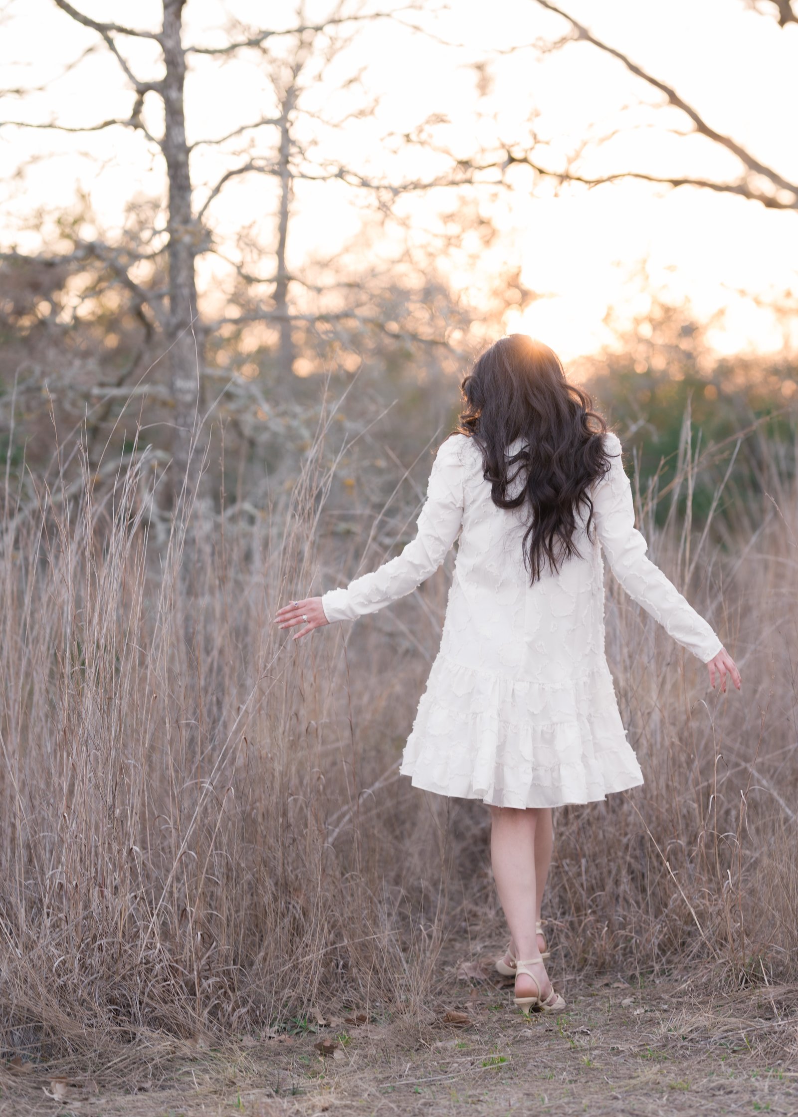 Teresa Vitela The Legacy - elegant woman walking into golden sunset glow white dress flowing open field College Station Texas
