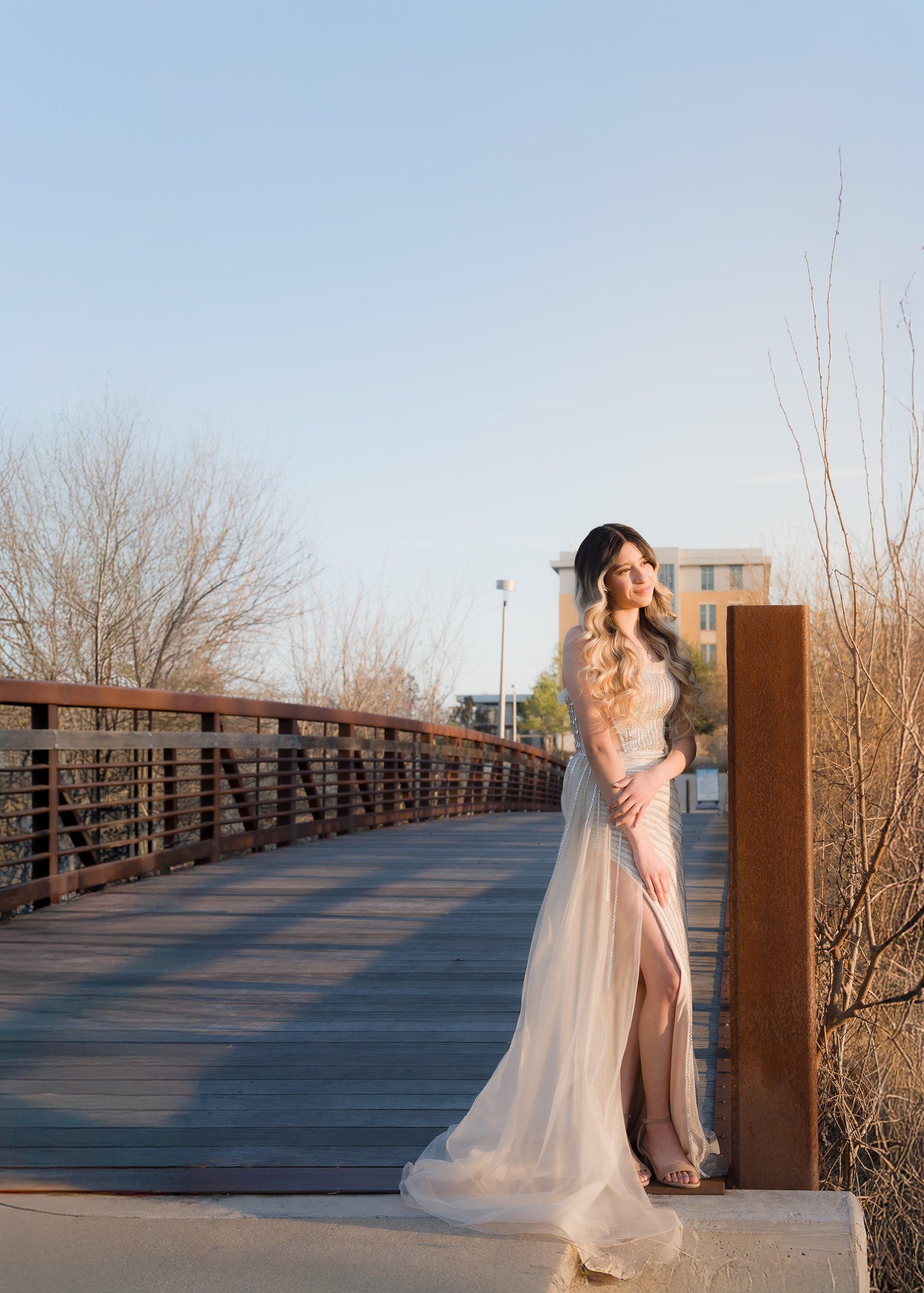 Teresa Vitela fine art senior photography - stunning young woman in elegant beige dress on bridge January Texas A&M Gardens Texas