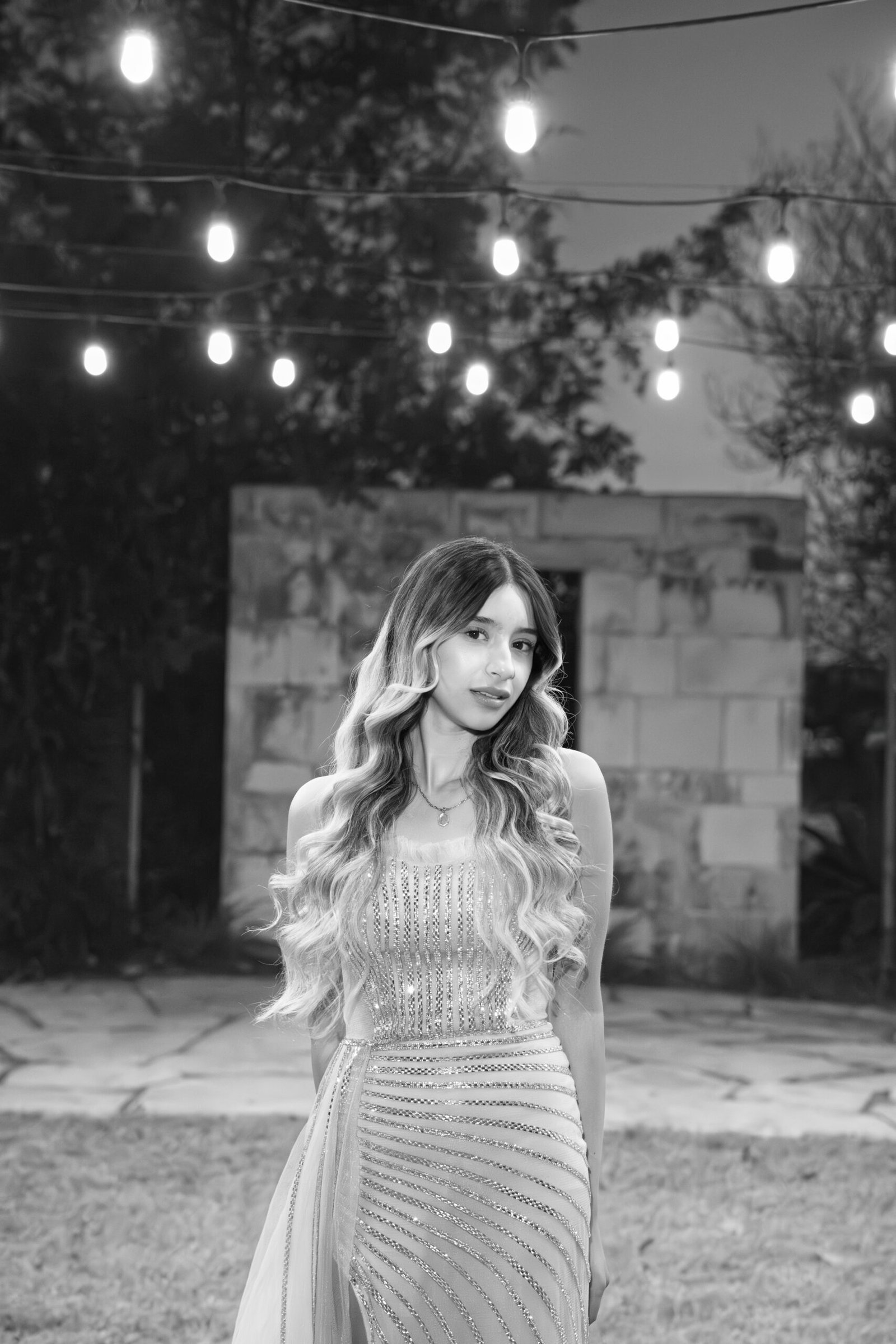 Teresa Vitela luxury senior session - Black and White portrait. magical string lights portrait young woman beige gown Texas A&M Gardens College Station Texas