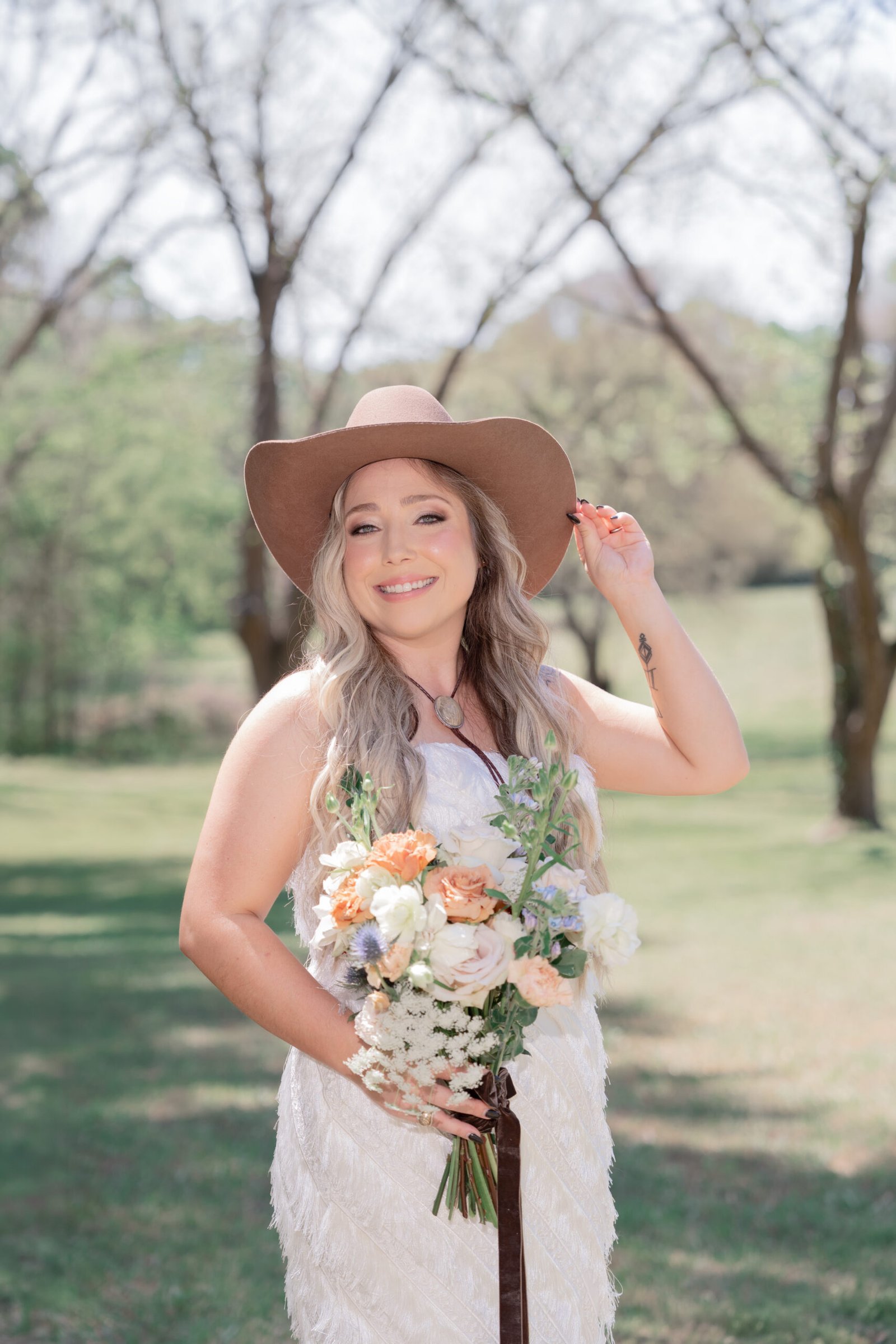 Texas bride in white dress and cowboy hat with bouquet — bridal portrait by Teresa Vitela Photography
