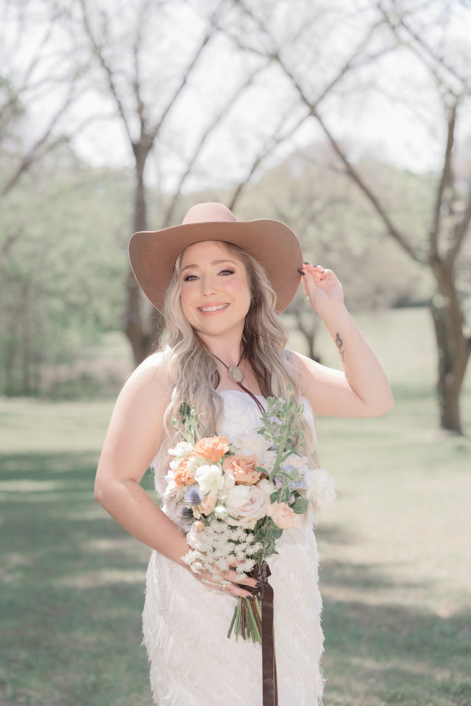 Texas bride in white dress and cowboy hat with bouquet — bridal portrait by Teresa Vitela Photography