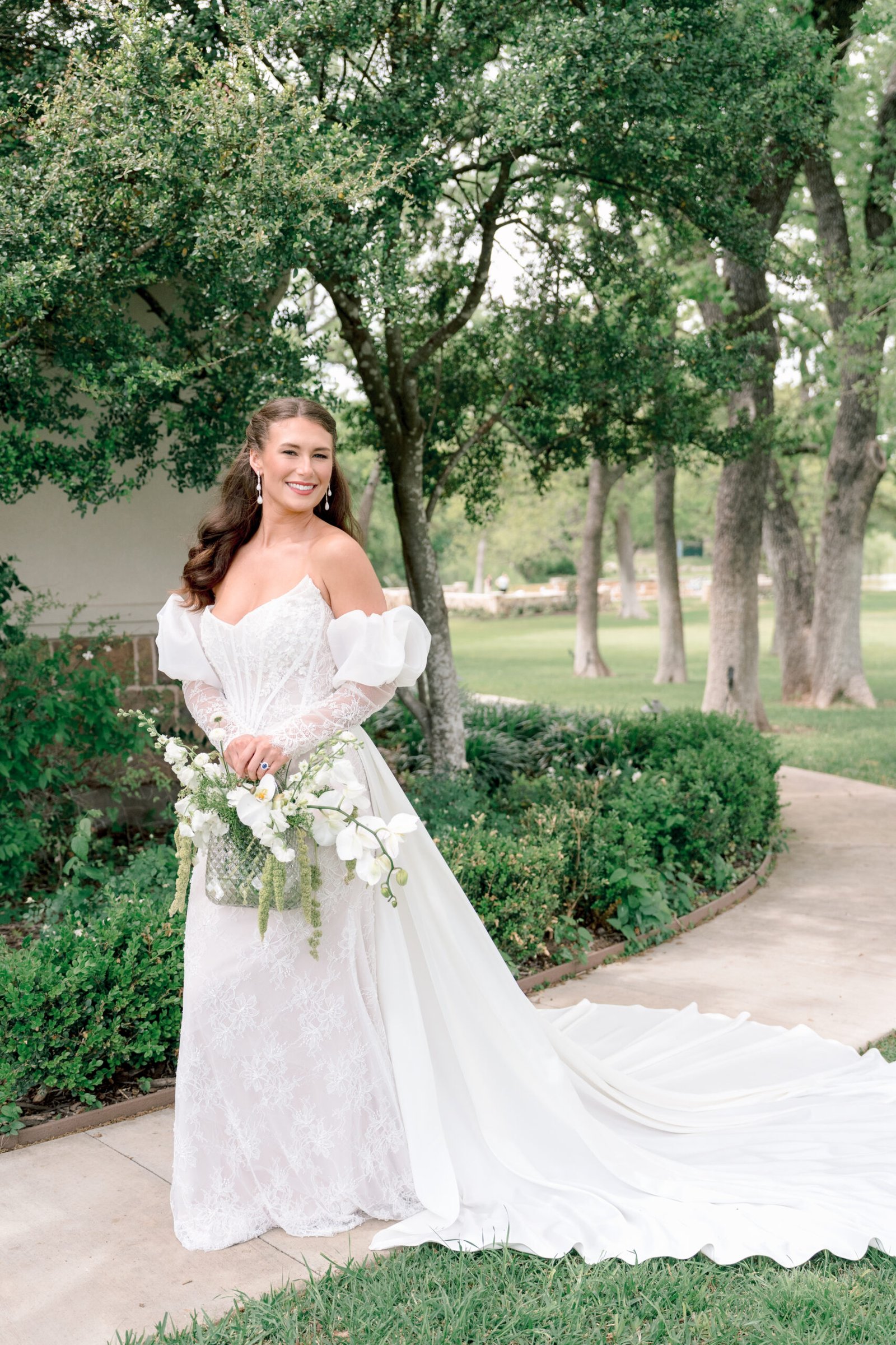 Fine Art bride in an off-shoulder lace gown walking through a Tuscan villa wedding venue in Dallas Texas.